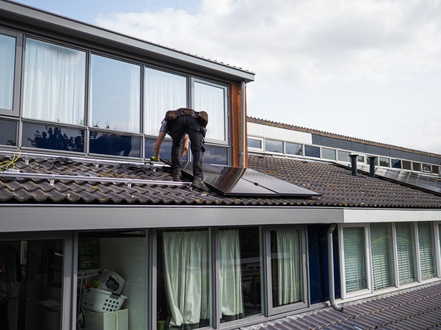 Technicien Teksol installant des panneaux solaires sur un toit